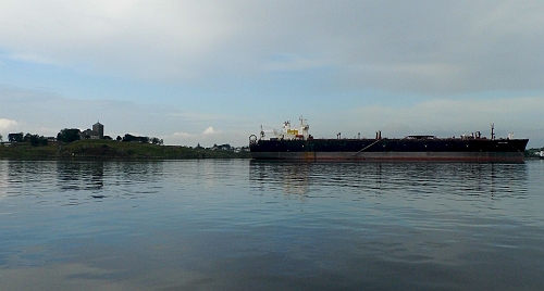 DSCI0040a.jpg - Krasser kann ein Gegensatz nicht sein! Rechts der Supertanker vor Anker, links die Kirche aus Zeiten, als Recht noch mit dem Blechschwert gesprochen wurde, und man Christiansierung noch fuer einen Segen hielt...