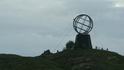 PIC_1351.JPG - Und dann endlich, nachdem uns auch noch der Regen, der schon den ganzen Tag hinter uns her war einhgeholt und ueberholt hat: Der Polarkreis ist erreicht! Das Uebersetzen mittels Dinghi sparen wir uns wegen des miesepetriegen Wetters