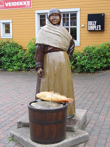 DSCI0242.JPG - Vor einem der vielen Fischrestaurants steht diese gemuetliche, hoelzerne Dame und preist ihren Dorsch und Heilbut an. Schade: auch aus Holz!