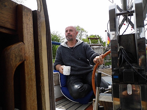 DSCI0220.JPG - Endlich wieder auf Tour! Der Skipper geniesst beim morgendlichen Tee die Fahrt. Aber nicht lange, dann kann mann auf dem Motor Eier braten. Eine Luftblase im Innenkuehlkreislauf hat sich gebildet, nachdem ich das Kuehlwasser ausgewechselt habe. Trotz Probefahrt, erst jetzt zeigt sich das Problem, das aber locker gemeistert wird. Einen Schreck bekommt man trotzdem...