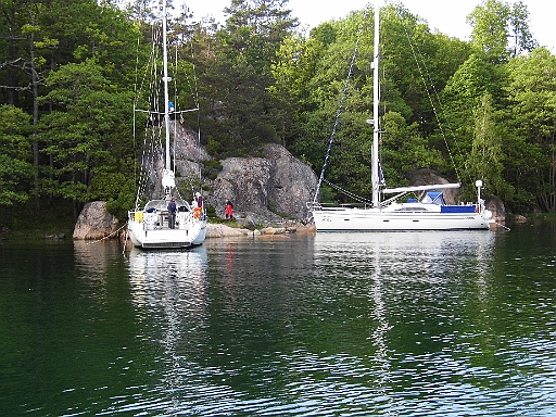 DSCI1127.JPG - Ja und dann ist es vorbei mit der Ruhe. Joerg Jonscher mit Chartercrew und befreundetem Boot kommen, wie uebrigens anngekuendigt, in unseren Teich. Es dauert einen ganze Weile, bis die beiden 45 Fuss Schuesseln fest sind. Nach dem Anleger bei Joerg an Bord kommen seine "Charterladys" doch glatt auf die verrueckte Idee mit dem Beiboot zum Ufer zu ruder und Baden zu gehen. Die Muecken haben sich natuerlich sofort ueber die nassen Leiber hergemacht. Selber schuld....abgesehen mal von der Wassertemperatur, brrrr.....