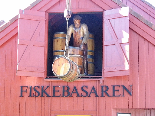 DSCI1160.JPG - Der hier steht auch prima in Farbe, denn er ist aus Holz. Coole Idee, so einen Holzkameraden als Reklame fuer den Fischladen zu nutzen. Das hat Stil und da kommt keine Leuchtreklame mit!