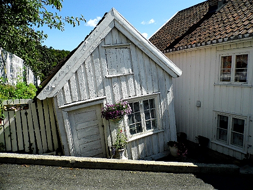 DSCI0578.JPG - Die Holzhaeuser in Tvedestrand scheinen allerdings haeufig in keinem so guten Zustand zu sein. Vor allem am Hafen. Nicht, dass jemand denkt, hier haette der Fotograf gewackelt: Dieses Haeuschen ist tatsaechlich so schief, wie es aussieht!