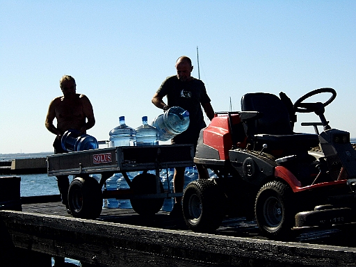 DSCI1632.JPG - Und dann sucht der Hafenmeister eine "Crew", um das Trinkwasser der Insulaner anzulanden. Es ist beschaemend, aber er findet keine - ausser mir. Macht nix. Ich nehms als Training. Es sind immer 20 L Flaschen...800 Liter