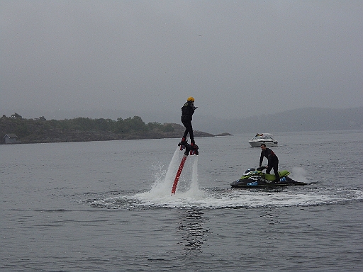 DSCI0005.JPG - Und das hier ist wohl der heisseste Knaller hier im Moment: Der rote Schlauch ist mit einer Turbopumpe unter dem Waterbike verbunden, die Wasser mit hohrem Druck in die beiden Duesen unter den Fuessen des jungen Mannes jagt. Und damit hebt er ab und schwebt minutenlang ueber dem Wasser - wenn er Glueck hat...