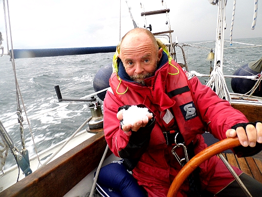 DSCI1970.JPG - Mit den Haenden schaufeln wir den Hagel aussenbords, denn es ist teuflich glatt an Deck. Noch wei Stunden spaeter haben wir Eis auf dem Plichtboden. Ein paar Tage vorher hat die Bordfee noch ueber meine extrem schwere alte Kombi geschimpft. Heute hat sie mich vor dem Hagelschlag bewahrt.